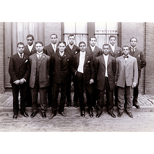 Twelve men pose for a group photograph