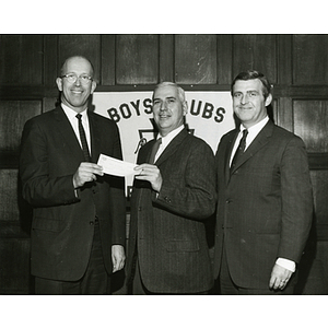 Charles H. Hood, at left, presents a check to an unidentified man and Frederick J. Davis, Executive Vice President of the Boys' Clubs of Boston