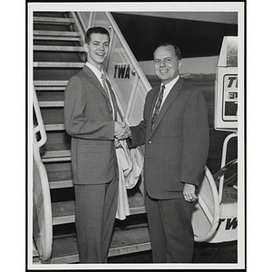 Richard J. O'Neil, at left, shakes hands with Paul F. Hellmuth, President of the Boys' Clubs of Boston, in front of an airplane