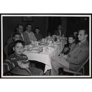 Men and boys sit at a table during a Dad's Club banquet