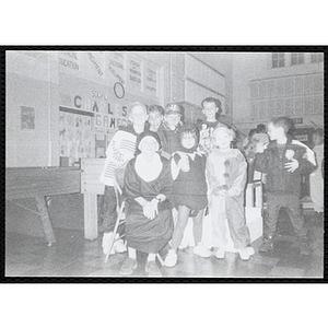 Children in costumes pose for a group shot at a Halloween event