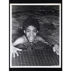 A boy wades in a natatorium pool