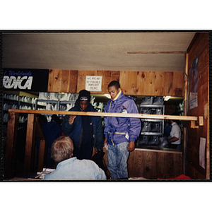 Two teenage boys stand in an equipment rental room at ski resort during a ski trip to Nashoba Valley