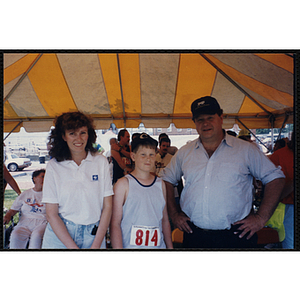 A boy poses with a woman and man during the Bunker Hill Road Race