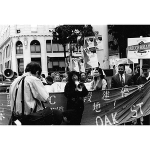 Woman addresses demonstrators rallying against the construction of a new garage on Parcel C in Chinatown