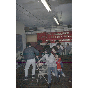 Chinese Progressive Association members playing musical chairs at a celebration for the Garment Workers' Center