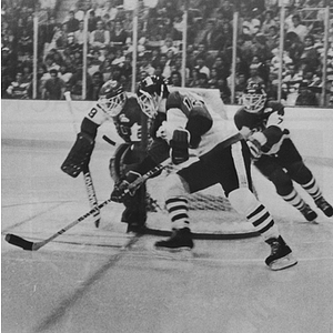 NU men's hockey player skating near Boston University's goal