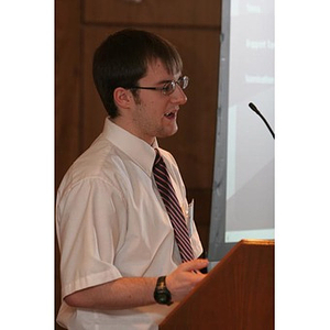 Jordan Munson speaks from a podium at a Torch Scholars event