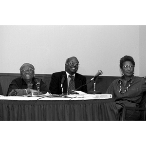 Three panelists smile during a symposium on civil rights