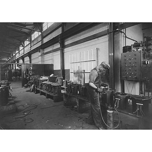 A student on his electrical engineering co-op job at Boston Edison's transformer repair shop