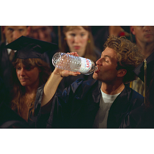 Student drinking water during commencement ceremony