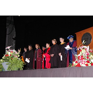 Faculty members stand onstage at School of Nursing convocation