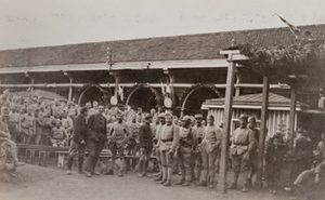 Large group of soldiers posing for a photo in front of a canteen