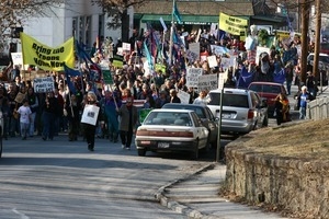 Anti-war marchers in the streets, led by banner reading 'Bring the troops home now': rally and march against the Iraq War