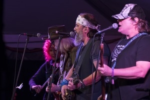 Kelly Looney (bass), Steve Earle (guitar), Chris Masterson (guitar), and Eleanor Whitmore (fiddle) performing onstage with Steve Earle and the Dukes at the Payomet Performing Arts Center
