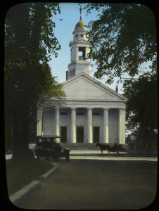 White classical style building (church or meeting house) along street with auto and horse