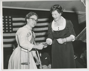 Unidentified woman handing gift to client at Institute Day