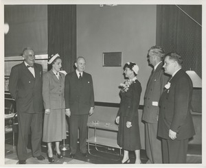 Jeremiah Milbank and others in front of the newman student lounge plaque