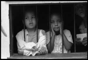 Girls looking out a barred window