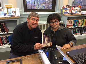 Joseph J. Melchionda, Jr shares a military photo of his Dad with us. Library staff member Alyssa True is ready to scan the photo.