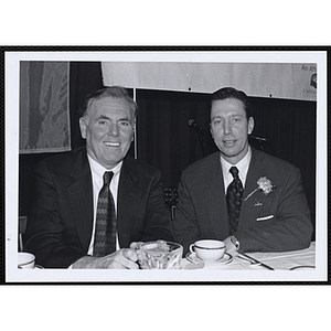 Raymond L. Flynn, former Mayor of Boston, seated on the left with an unidentified man at a St. Patrick's Day Luncheon