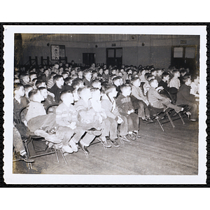 Boys' Club members sitting in chairs in the Charlestown Clubhouse auditorium, looking to their left