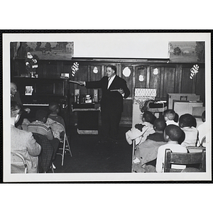 An unidentified man addresses a group of boys during a Christmas event