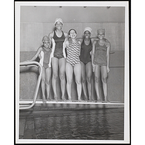 Five teenage girls pose for a group shot in a natatorium pool