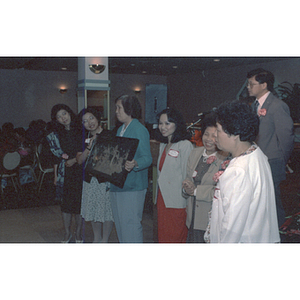 Guests and Suzanne Lee with artwork at Chinese Progressive Association's 15th Anniversary Celebration