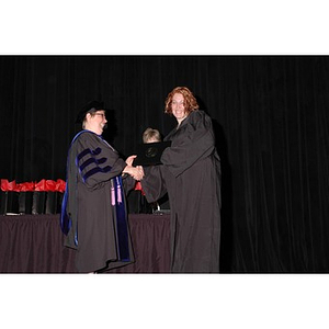 Faculty member presents student with gift bag at School of Nursing convocation