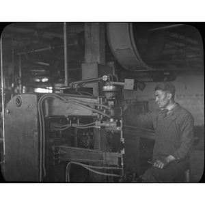 Engineering student works on a machine while on co-op at United Shoe Machinery Corp