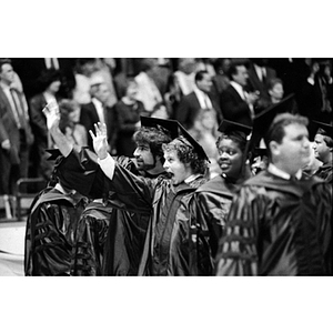 Graduating law students wave as they wait in line for their diplomas