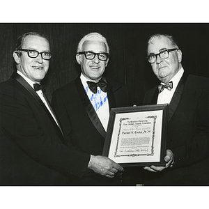 Herbert E. Tucker, Jr. poses with his Man of the Year Award and two others