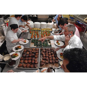 A chef, right, instructing his staff during the preparation of a dinner honoring members of the Huntington Society