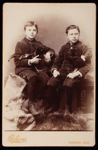 Two boys in studio portrait with chickens