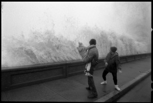 Judy Salonia, her husband Vincent, and daughter Ashley (4) watch as a huge surge crashes against the Narragansett seawall