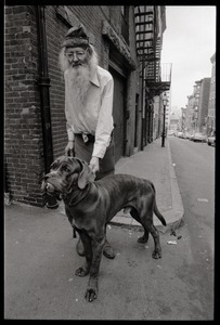 Prescott Townsend standing with a large dog on a Beacon Hill street