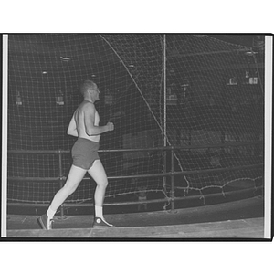 Man running along raised indoor track