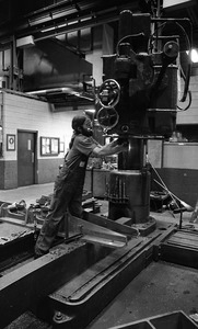 Worker adjusting drill press