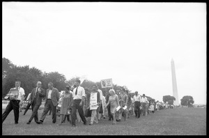 Marchers on the National Mall carrying anti-war signs, heading toward the U.S. Capitol building (Washington Monument in the background)