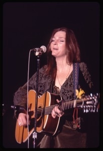 Judy Collins: in green velvet dress with guitar, performing on stage