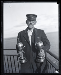 Lighthouse keeper holding a pair of lanterns