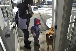 Mother and child leaving the New Salem Public Library, greeted by a waiting golden retriever