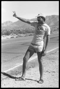 Peace encampment activist flashing peace sign near entrance to the Nevada Test Site