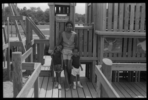 Irma McClaurin with two children atop playground equipment
