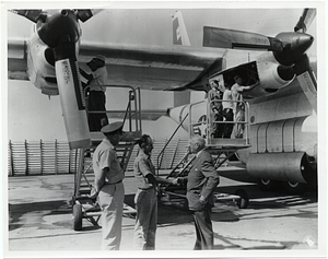 Mark Bortman with unidentified men in front of an aircraft