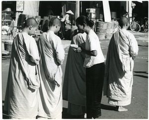 Woman giving food to Buddhist nuns