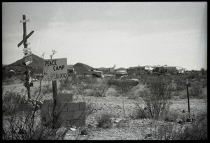 Nevada Test Site peace encampment with waymarker and sign reading 'Peace camp, Pop. 1-10,000'