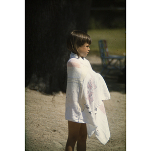 Young girl wrapped in a towel at the beach