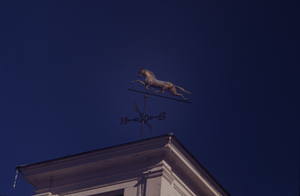 Running horse weathervane and west facade of clock tower on the Buxton Farms carriage house.